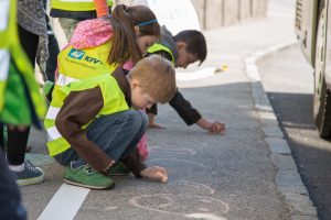 Kinder mit Warnweste steigen in den Bus ein