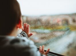 Baby beim Fenster schaut raus.