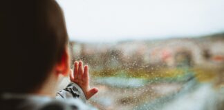 Baby beim Fenster schaut raus.