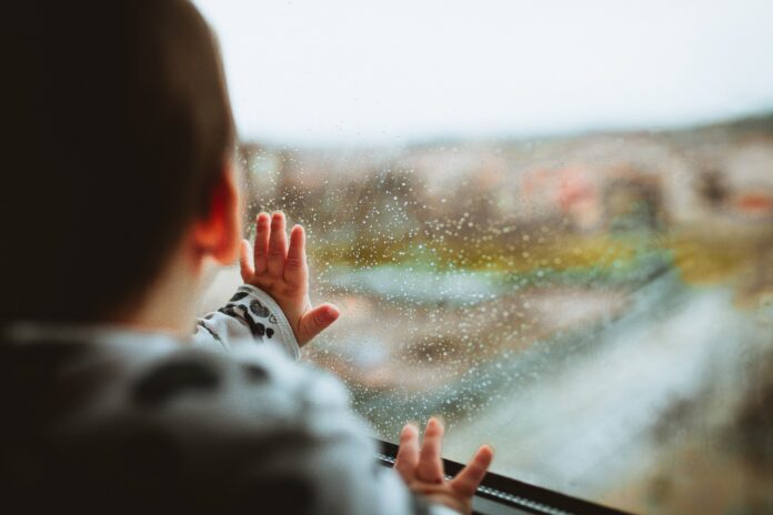 Baby beim Fenster schaut raus.