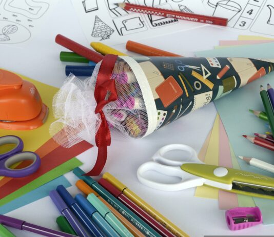 Eine gefüllte Schultüte zwischen Schulmaterialien.