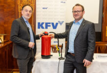 Dr. Armin Kaltenegger (KFV) und Dr. Günther Schwabegger (BVS OÖ) bei der Pressekonferenz. Zwischen ihnen steht ein Feuerlöscher, hinter ihnen ein Roll-Up mit dem Logo des KFV.