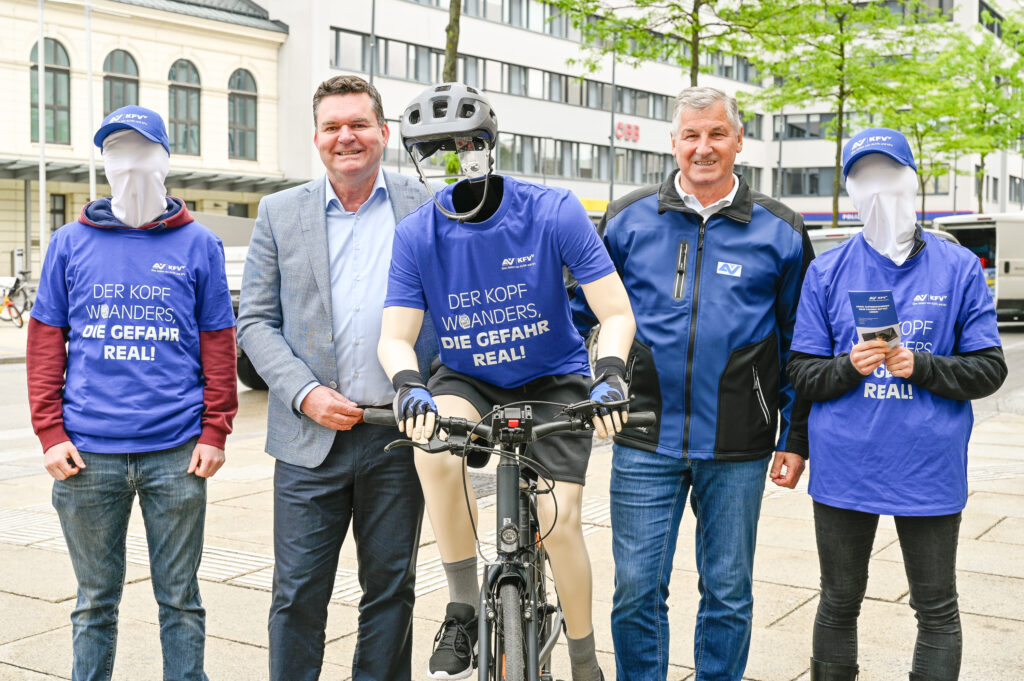 Dipl.-Ing. Christian Kräutler (KFV) zwischen Aktionsmitarbeitendem und der kopflosen Radfahrer-Puppe. Daneben Komm. Rat Peter Engelbrechtsmüller (Vorsitzender der zuständigen AUVA-Landesstelle für Wien/NÖ/Burgenland) mit wiederum einer kopflosen Aktionsmitarbeitenden.