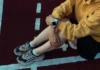Person sitzt auf der Laufbahn und trägt eine Smartwatch