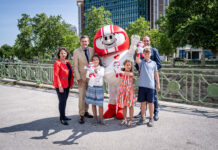 Doris Wendler, Präsidentin des KFV (Kuratorium für Verkehrssicherheit), Mobilitätsminister Peter Hanke, Kult-Maskottchen HELMI, Christian Schimanofsky, Geschäftsführer des KFV und begeisterte Kinder freuen sich auf die Aktion und stehen vor dem Bundesministerium.
