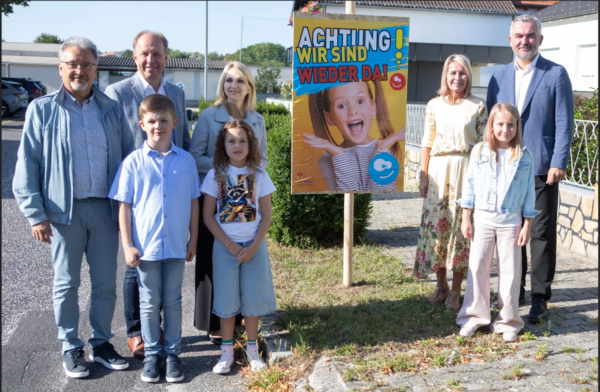 Personen stehen neben einem Plakat