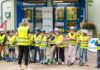 Eine Klasse im Hof mit Warnwesten und Helmen.