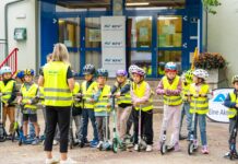 Eine Klasse im Hof mit Warnwesten und Helmen.