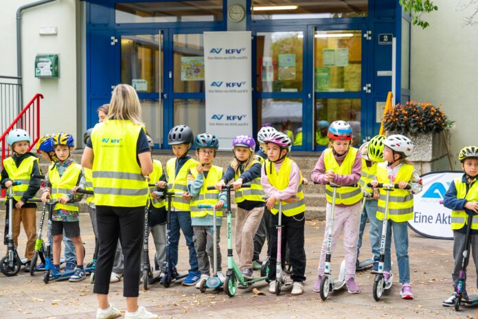 Eine Klasse im Hof mit Warnwesten und Helmen.