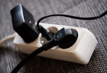 Eine Mehrfachsteckdosen-Leiste mit 3 Steckdosen, die alle genutzt werden durch verschiedene schwarze Stecker.