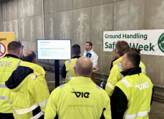 13 Workshops, 905 Teilnehmende: Flughafen Wien setzt starkes Zeichen gegen Ablenkung im Straßenverkehr Eine Gruppe Mitarbeitende des Wiener Flughafens stehen zusammen und hören sich einen Vortrag an.