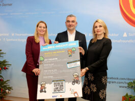 Zwei Frauen und ein Mann halten ein Plakat zur Kampagne hoch. Das Design erinnert an ein Videospiel mit Pixelgrafiken.