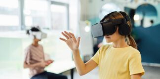 Zwei Mädchen mit VR-Brillen bewegen sich in einem Raum.