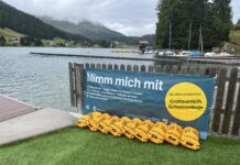 Vorzeigeprojekt der BFU Schweiz nun auch in Österreich: Kostenloser Schwimmbojen-Verleih erhöht die Sicherheit in offenen Gewässern Gelbe Schwimmbojen aneinandergereiht am Ufer eines Sees. An dem Zaun vor dem Steg ist ein Banner angebracht mit dem Text: "Nimm mich mit. Boje nehmen - Gegenstände ins Staufach packen. 3x wickeln, verschließen - Hüftgurt umlegen. Schwimmen - zum Ausruhen über die Boje lehnen. Boje zurückbringen. Nie allein schwimmen. Gratisverleih Schwimmboje"