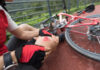 Ein Radfahrer mit einem aufgeschlagenen Knie und einem umgekippten Rad daneben.