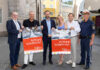 Sechs Personen, die zwei Plakate zu "Achtung Schulkinder" hochhalten für das Land Salzburg und in die Kamera lächeln.